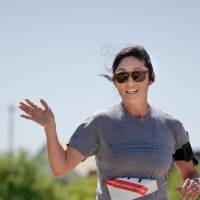 A racer waves while running.